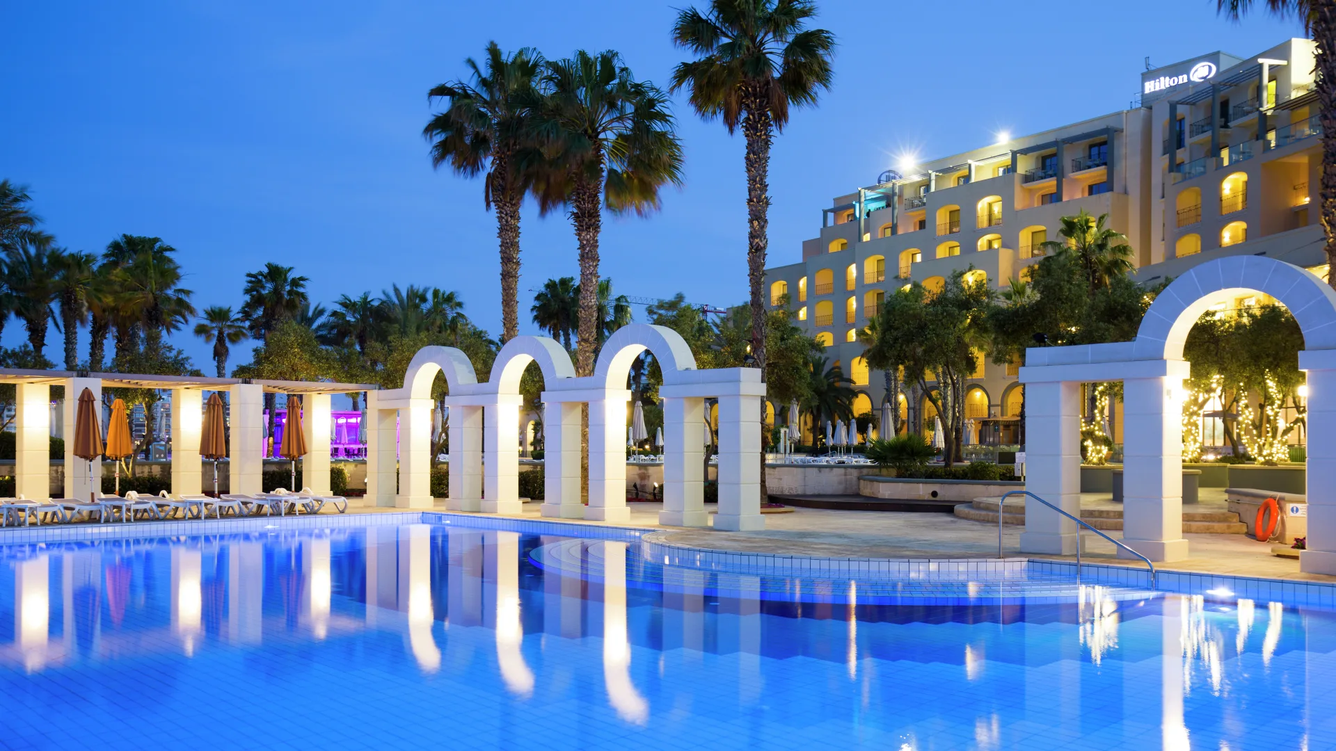 Hilton Malta poolside arches at dusk